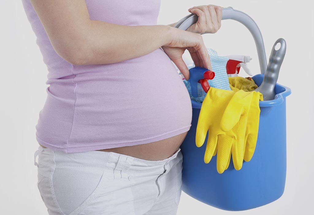Mulher grávida limpando a casa