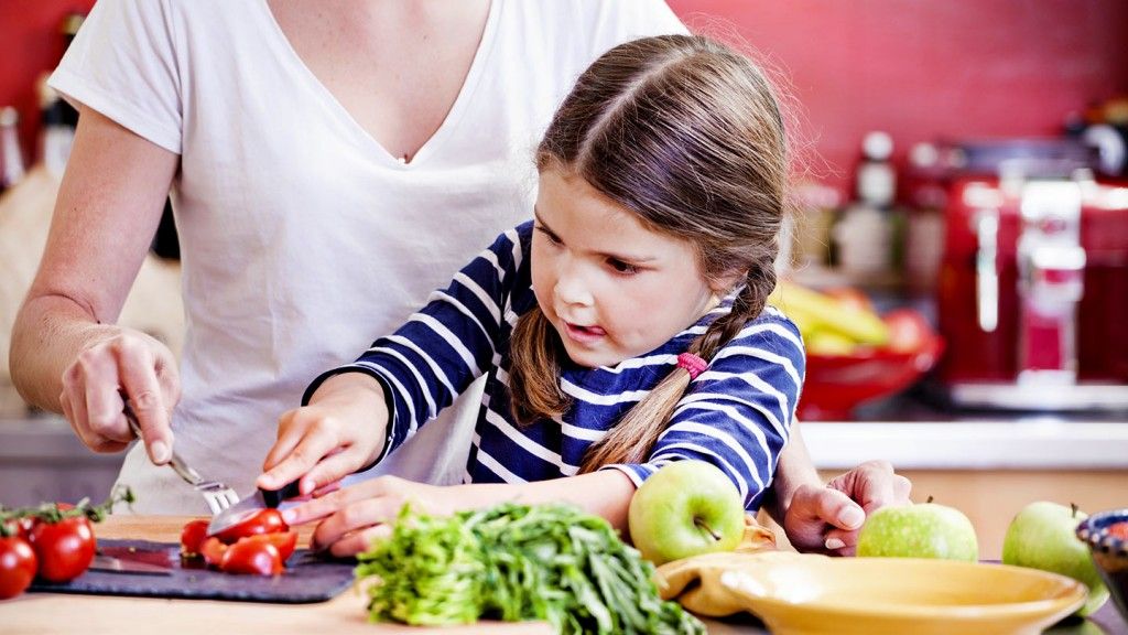 Criança cozinhando com a mãe