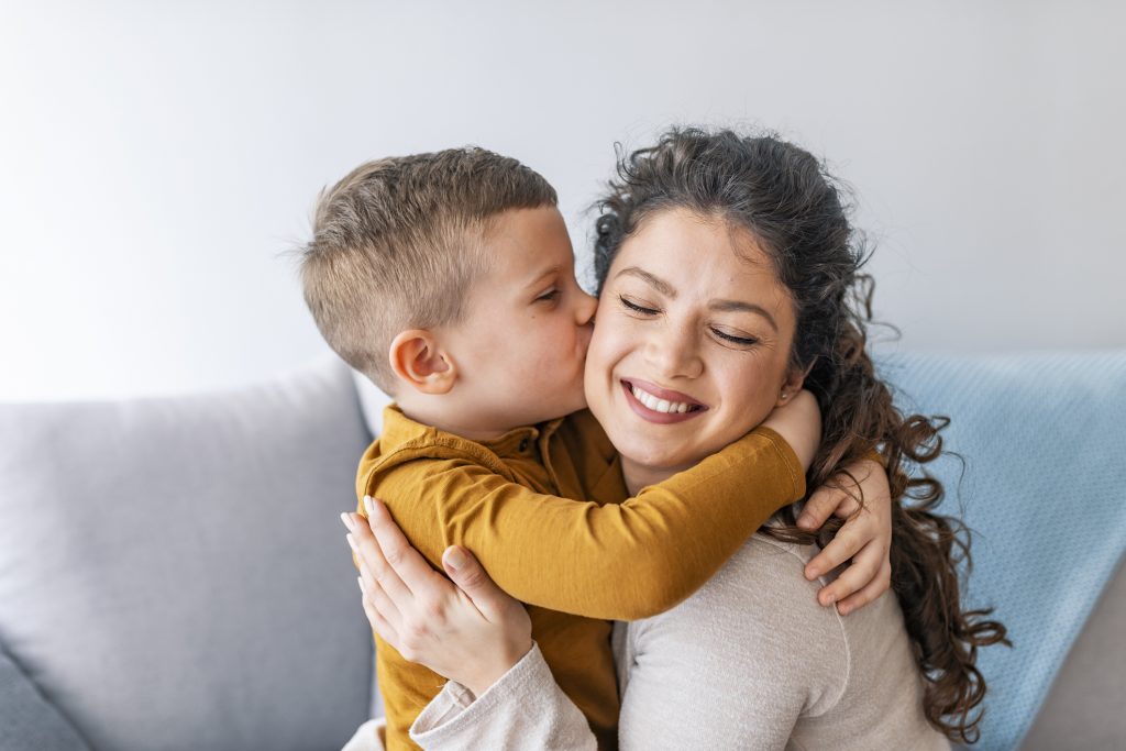 Mãe solteira recebendo beijo do filho