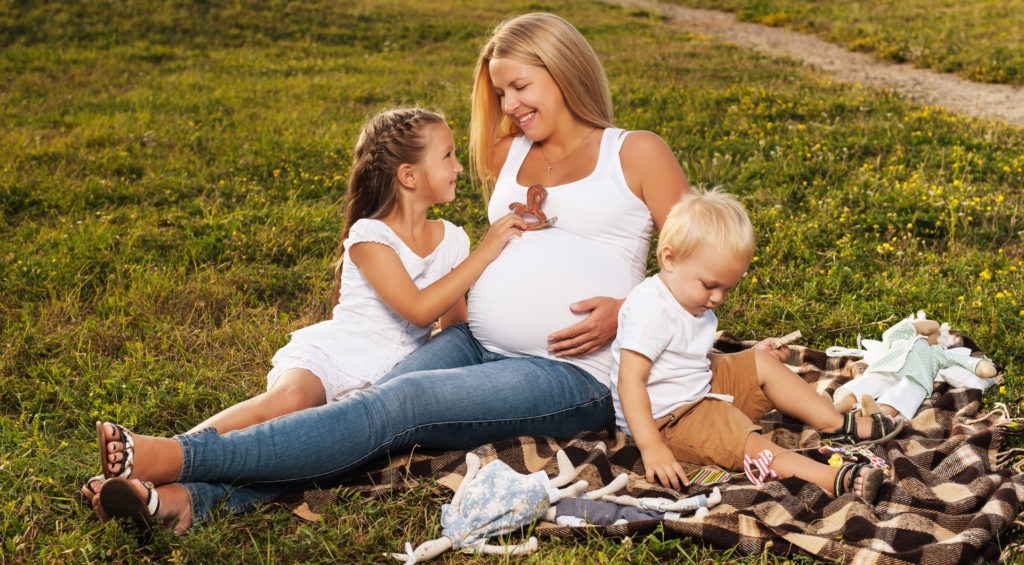 Mãe com seus vários filhos, um ainda na barriga.