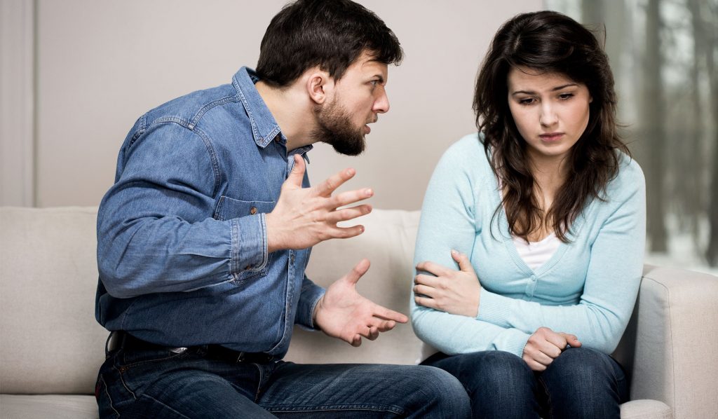 Homem conversando com mulher de forma agressiva.